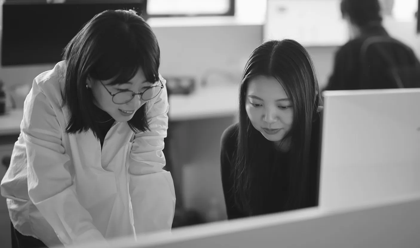 協力してアイデアを共有するCoosyのスタッフ2人